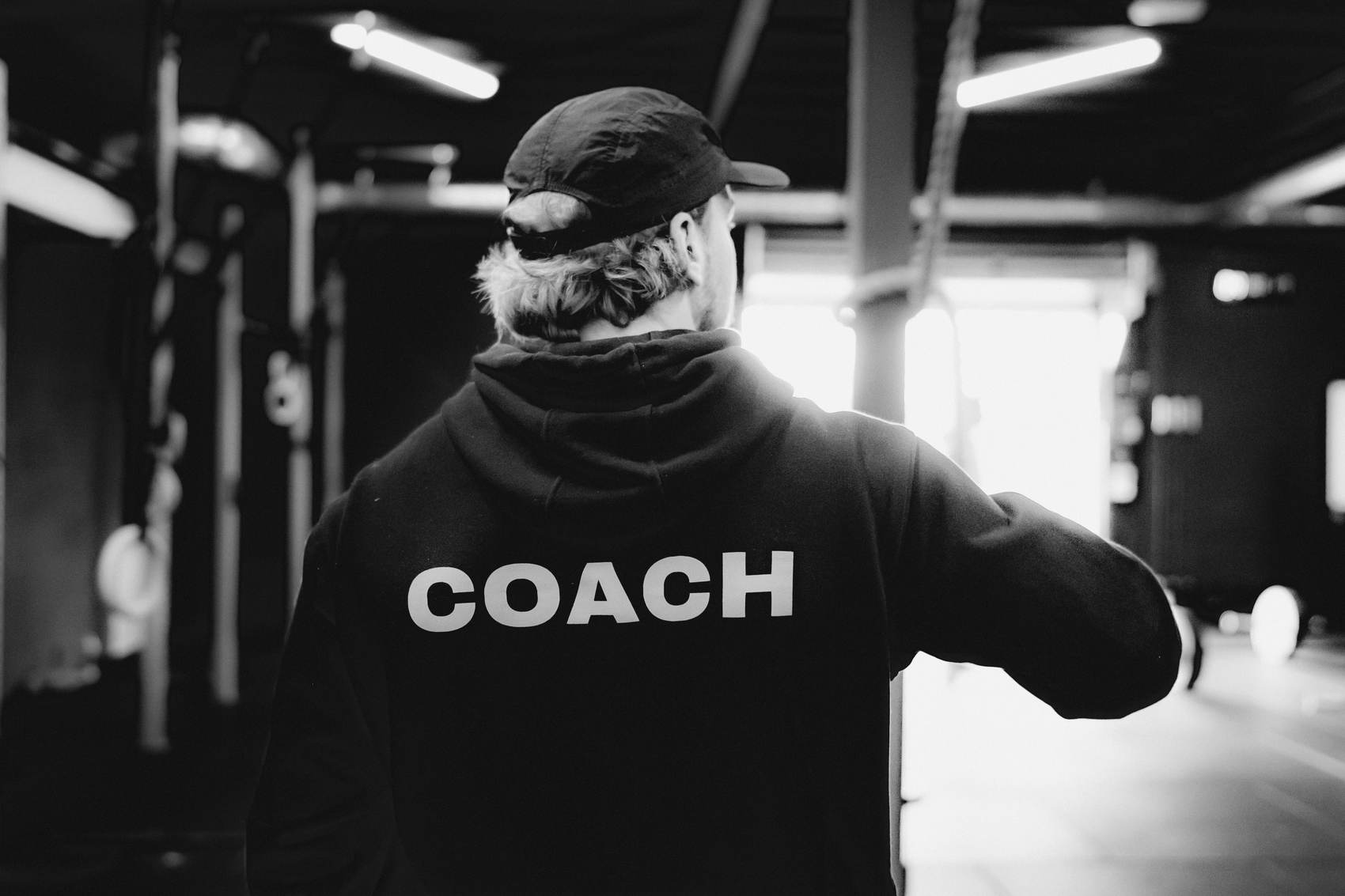 Coach van The Box, met COACH op de rug van zijn hoodie.