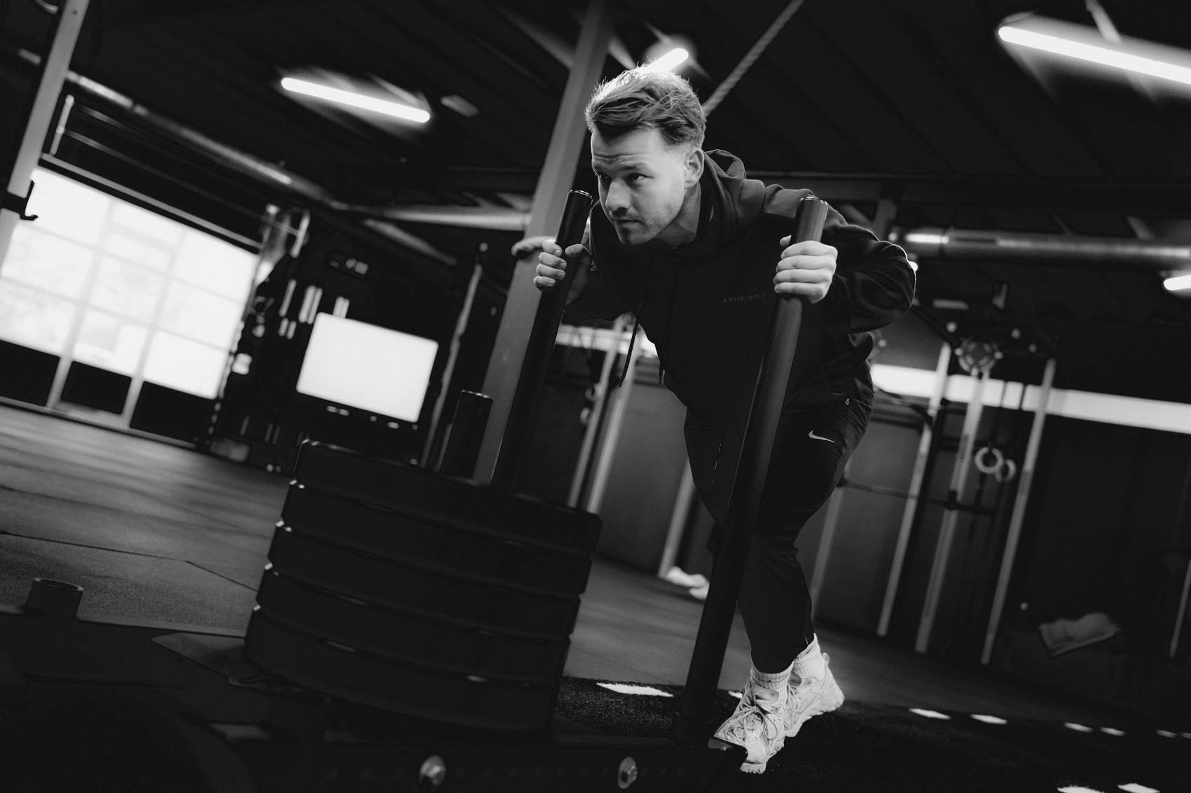 Atleet duwt een sled tijdens een All Sides-les.